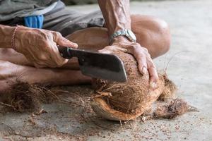 hand while cutting and opening fresh coconut photo