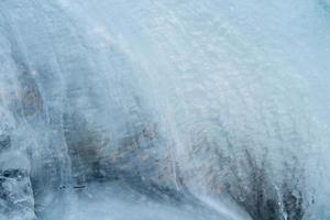 Frozen creek small waterfall in winter time photo