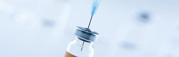 Medical syringe with a needle and a bollte with vaccine. photo