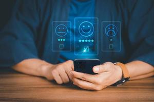 Man using a mobile phone in give rating to service experience on application. Online customer review satisfaction feedback survey. photo