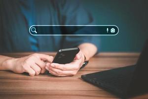 Man using a mobile phone in the room for searching browsing internet data information. Business concept for Using search with your website. photo