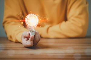 Man touching a bright light bulb. Ideas for presenting new ideas, inspiration in the work and innovation new beginning. photo