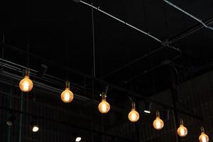 luces cálidas colgando del techo en un restaurante local. primer plano con fondo borroso. espacio de copia negativa
