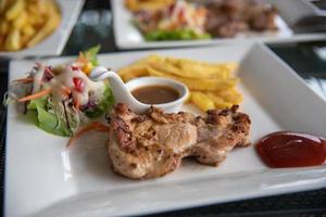 Steak chicken and salad vegetable in dish on table. photo