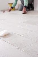 worker installing the ceramic wood effect tiles on the floor photo