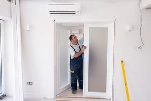 carpenters installing glass door with a wooden frame photo