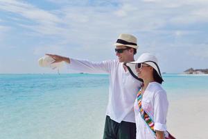 feliz pareja joven divertirse en la playa foto