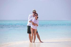 feliz pareja joven divertirse en la playa foto