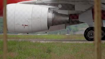 motor a reacción de avión y trenes de aterrizaje avanzando. primer plano de los neumáticos de las ruedas del tren de aterrizaje en un avión de pasajeros moderno. el avión está rodando a lo largo de la plataforma del aeropuerto video