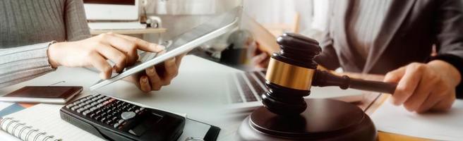 Business and lawyers discussing contract papers with brass scale on desk in office. Law, legal services, advice, justice and law concept picture with film grain effect photo