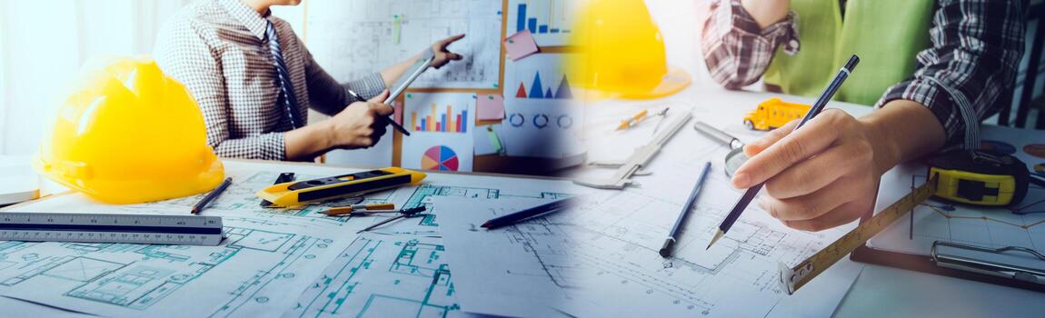 Two colleagues discussing data working and tablet, laptop with on on architectural project at construction site at desk in office photo