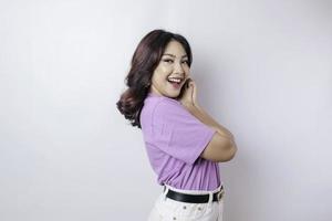 un retrato de una mujer asiática feliz con una camiseta violeta lila aislada de fondo blanco foto