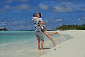 feliz pareja joven divertirse en la playa foto