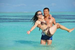 happy young  couple enjoying summer on beach photo