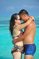 feliz pareja joven disfrutando del verano en la playa foto