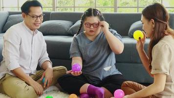 la familia asiática juega un juego de lanzar la pelota felizmente en casa de vacaciones. video