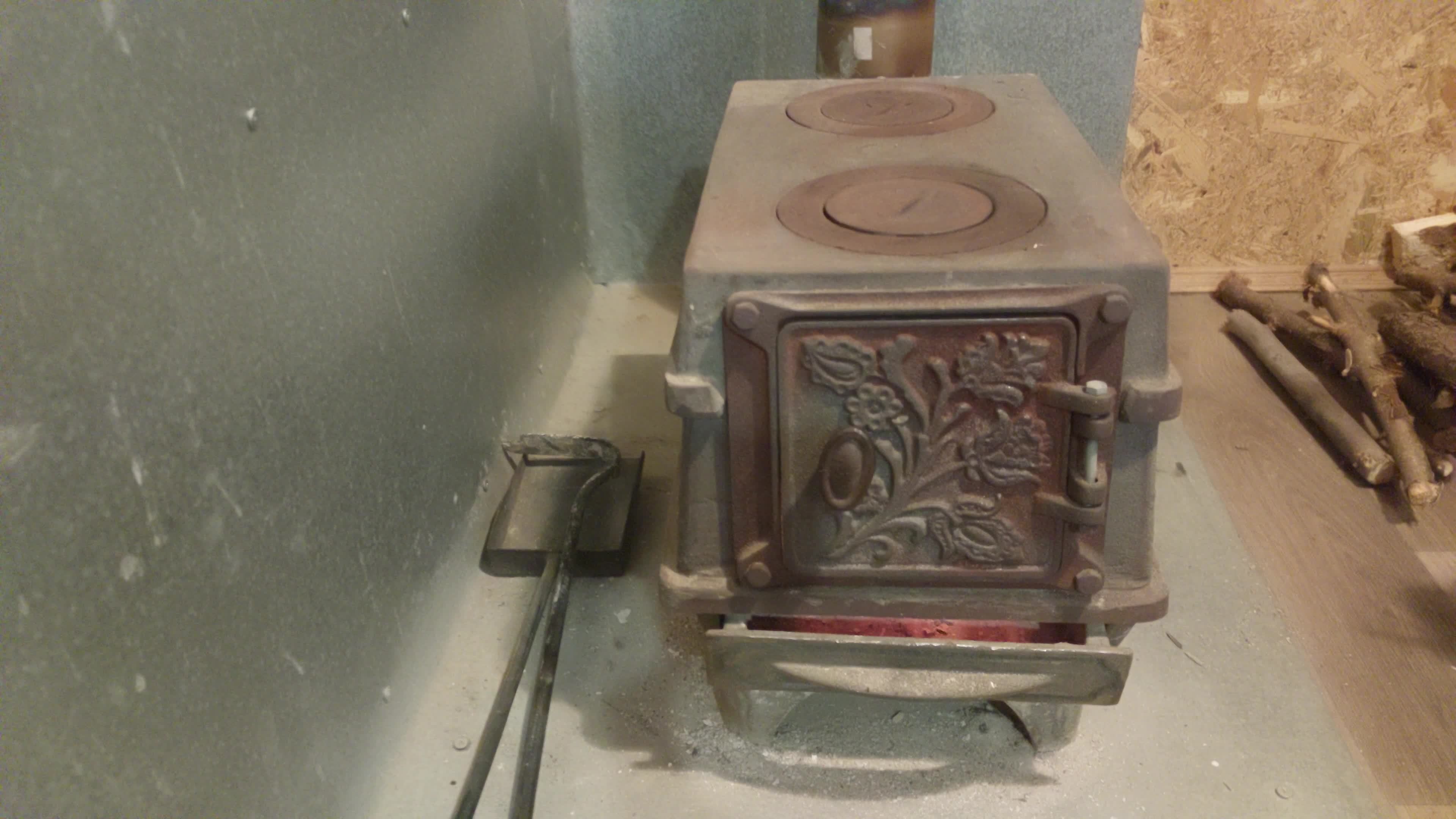 Firewood burning in a castiron stove warming the house 11961964 Stock