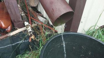 Rainwater dripping from a drain into a bucket video