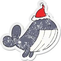 distressed sticker cartoon of a whale wearing santa hat vector