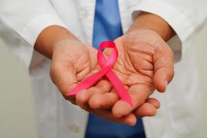 Asian woman doctor with pink ribbon, World Breast Cancer Day at October. photo