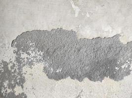 Old Wall damaged with blown Plaster and paint clog,peeling paint damage,water damage on building wall.Grunge abstract background.Wall fragment with scratches and cracks.Old distressed wall backdrop. photo