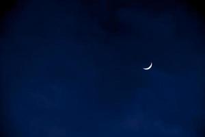 Half Moon in the early evening on dark blue sky, photo