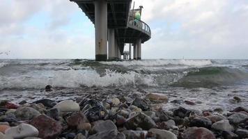 View of the stormy Baltic Sea under a pier in Niendorf on Timmendorfer Strand. video