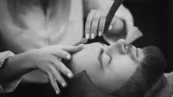 Bearded man with beard getting stylish hair shaving photo