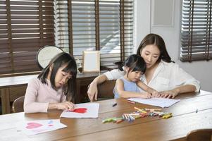 Asian family with children Drawing and painting on table in playing room at home, Educational game. photo