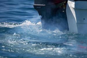 motor boat engine smoke on water detail photo