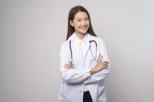 retrato de una doctora segura de sí misma sobre un estudio de fondo blanco, concepto de tecnología médica y asistencia sanitaria. foto