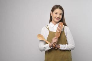 retrato de una joven asiática con delantal sobre estudio de fondo blanco, concepto de cocina y emprendedor