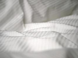 Hotel bed white sheets detail photo