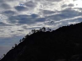paraglider on cloudy sky in monterosso cinque terre italy photo