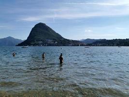 lugano, suiza - 23 de junio de 2019 - vista del paisaje urbano de lugano desde el lago lleno de gente foto