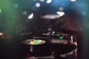 Vinyl record in the dance club with disc jockey photo