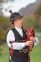 Typical player in traditional northern Italy bagpipe costume, an alpine valley of Bergamo photo