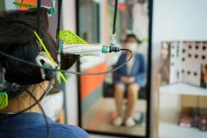 una joven asiática tiene un corte de pelo y un spa con un peluquero de belleza profesional. mujer sentada en la silla de belleza - salón de belleza mientras el peluquero le corta el pelo. foto