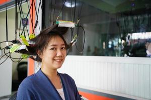 una joven asiática tiene un corte de pelo y un spa con un peluquero de belleza profesional. mujer sentada en la silla de belleza - salón de belleza mientras el peluquero le corta el pelo. foto