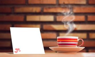 A bright pink metallic coffee cup on vacation.  And there is a blank sheet of note paper for inserting the contents. mock up and copy space photo