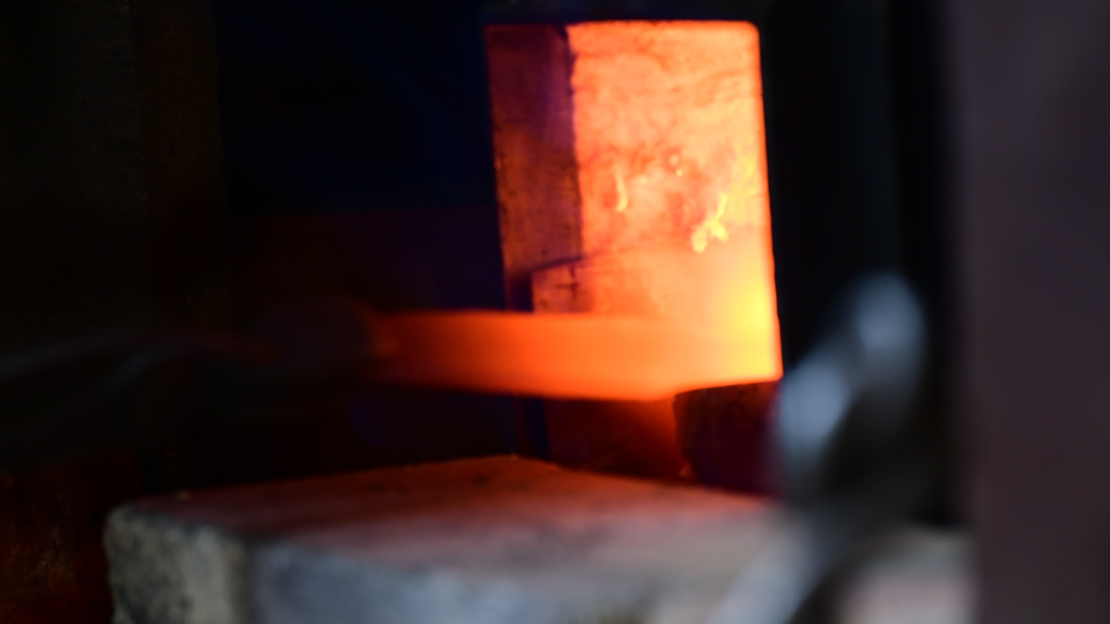 Man hitting a red metal. Making a blade of a knife in Black smith