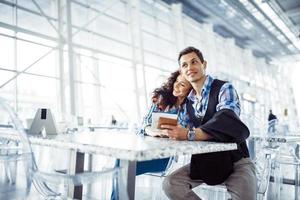 hermosa chica con un chico en el aeropuerto en el avión esperado foto