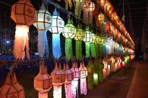 Beautifully shaped and colorful paper lanterns are hung in front of a pagoda to worship Lord Buddha in a temple in northern Thailand. photo