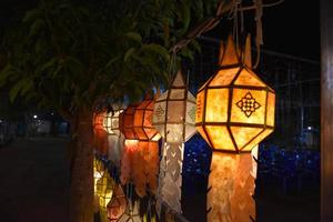 Beautifully shaped and colorful paper lanterns are hung in front of a pagoda to worship Lord Buddha in a temple in northern Thailand. photo