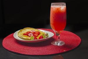 fresas y tortitas con jarabe en el plato blanco foto