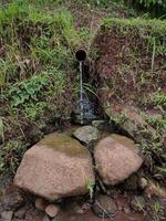 fotos de la eliminación de agua simple del agricultor, durante el día. hecho con materiales simples usando bambú. algunos usan una pipa.