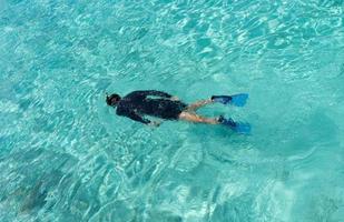 mujer joven buceando en aguas tropicales foto