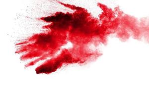 Abstract red dust splattered on white background. Red powder explosion.Freeze motion of red particles splashing. photo