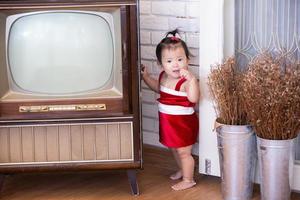 Little baby girl in red costume on Christmas day. photo