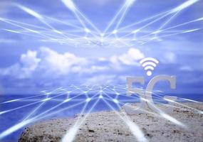 símbolo de 5g blanco con wifi y red de transmisión en la playa de piedra con cielo azul. red internet, comunicación inalámbrica y estándar 5g de concepto social de señal. foto